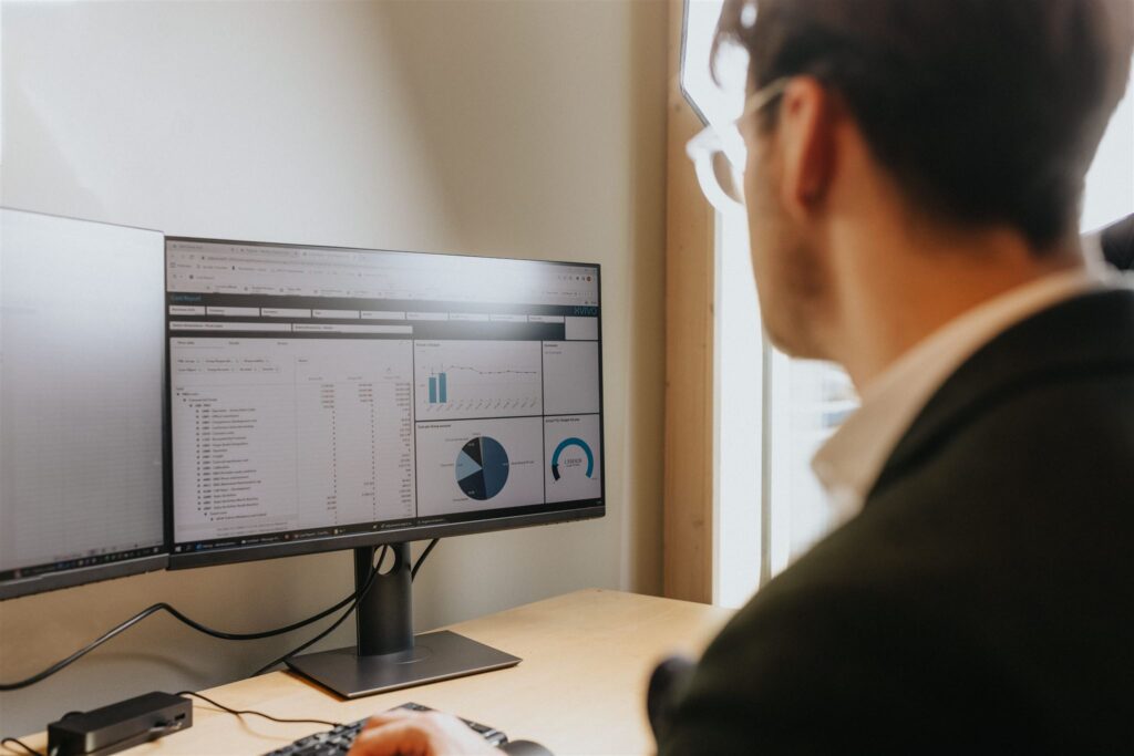 Man by computer showing graphs
